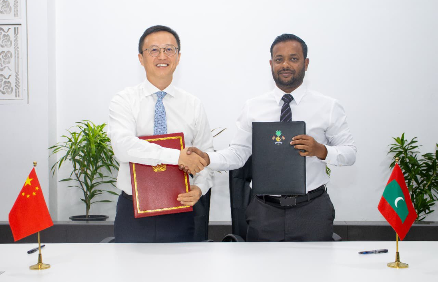 ޗައިނާ ސަރުކާރުގެ އެހީގައި މާލެއާއި ވިލިމާލޭގެ މަގުތައް ތަރައްގީކުރުމުގެ މަޝްރޫއުގެ ލެޓާ އޮފް އެކްސްޗޭންޖްގައި ހައުންސިން މިނިސްޓަރު އަބްދުﷲ މުއްތޮލިބާއި ޗައިނާ ސަފީރު ކޮން ޝިއަންވާ ސޮއިކުރައްވަނީ. ފޮޓޯ: ހައުސިން މިނިސްޓްރީ