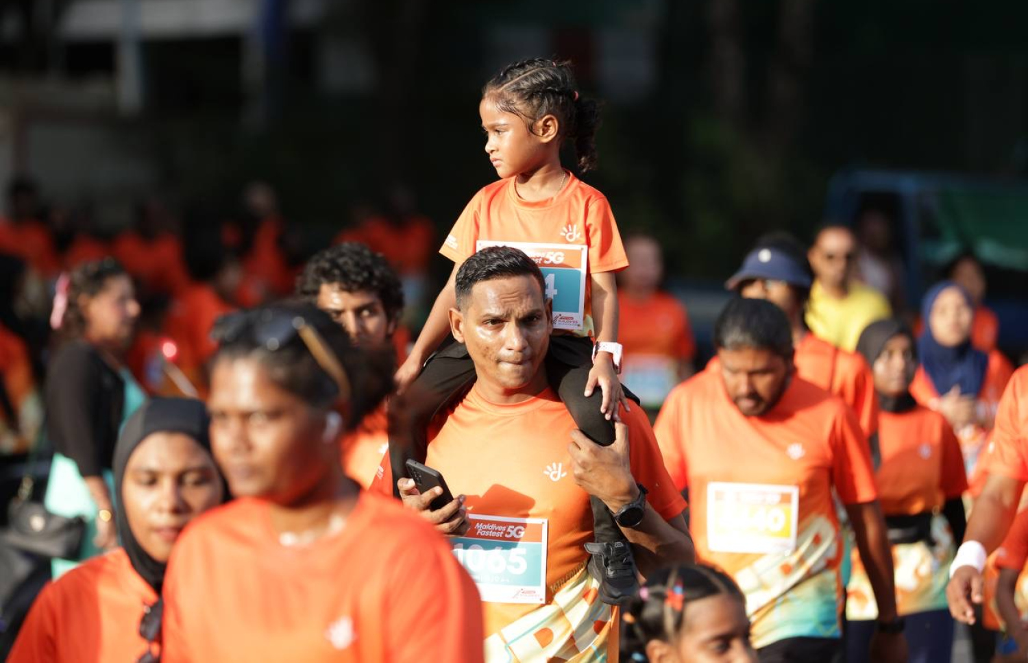 ރާއްޖޭގައި ބާއްވާ ދުވުމުގެ އެންމެ ބޮޑު ރޭސް، ދިރާގު މޯލްޑިވްސް ރޯޑް ރޭހުގައި މީހަކު ކުޑަކުއްޖަކު އުރާލައިގެން ދުވަނީ.--- ފޮޓޯ: ދިރާގު