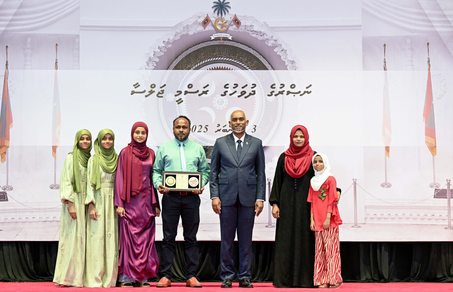 މި އަހަރުގެ ނަސްރުގެ ދުވަސް ފާހަގަކުރަން މިއަދު ބޭއްވި ރަސްމީ ޖަލްސާގައި، ނޮވެމްބަރު 3 ގެ ހަމަލާތަކުގައި ޝަހީދުވި މީހެއްގެ އާއިލާ އަށް ރައީސް. މުއިއްޒު އެރުވި އައްޑަނައާ އެކު، ފޮޓޯއަކަށް ހުއްޓިގެން.--- ފޮޓޯ: ރައީސް އޮފީސް