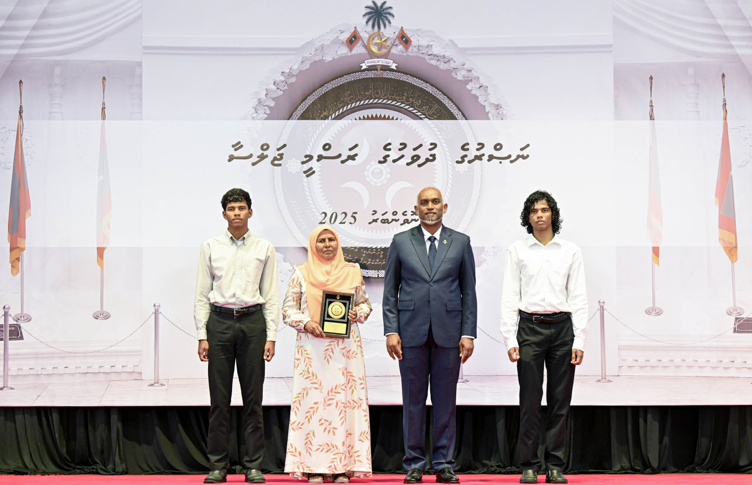 މި އަހަރުގެ ނަސްރުގެ ދުވަސް ފާހަގަކުރަން މިއަދު ބޭއްވި ރަސްމީ ޖަލްސާގައި، ނޮވެމްބަރު 3 ގެ ހަމަލާތަކުގައި ޝަހީދުވި މީހެއްގެ އާއިލާ އަށް ރައީސް. މުއިއްޒު އެރުވި އައްޑަނައާ އެކު، ފޮޓޯއަކަށް ހުއްޓިގެން.--- ފޮޓޯ: ރައީސް އޮފީސް