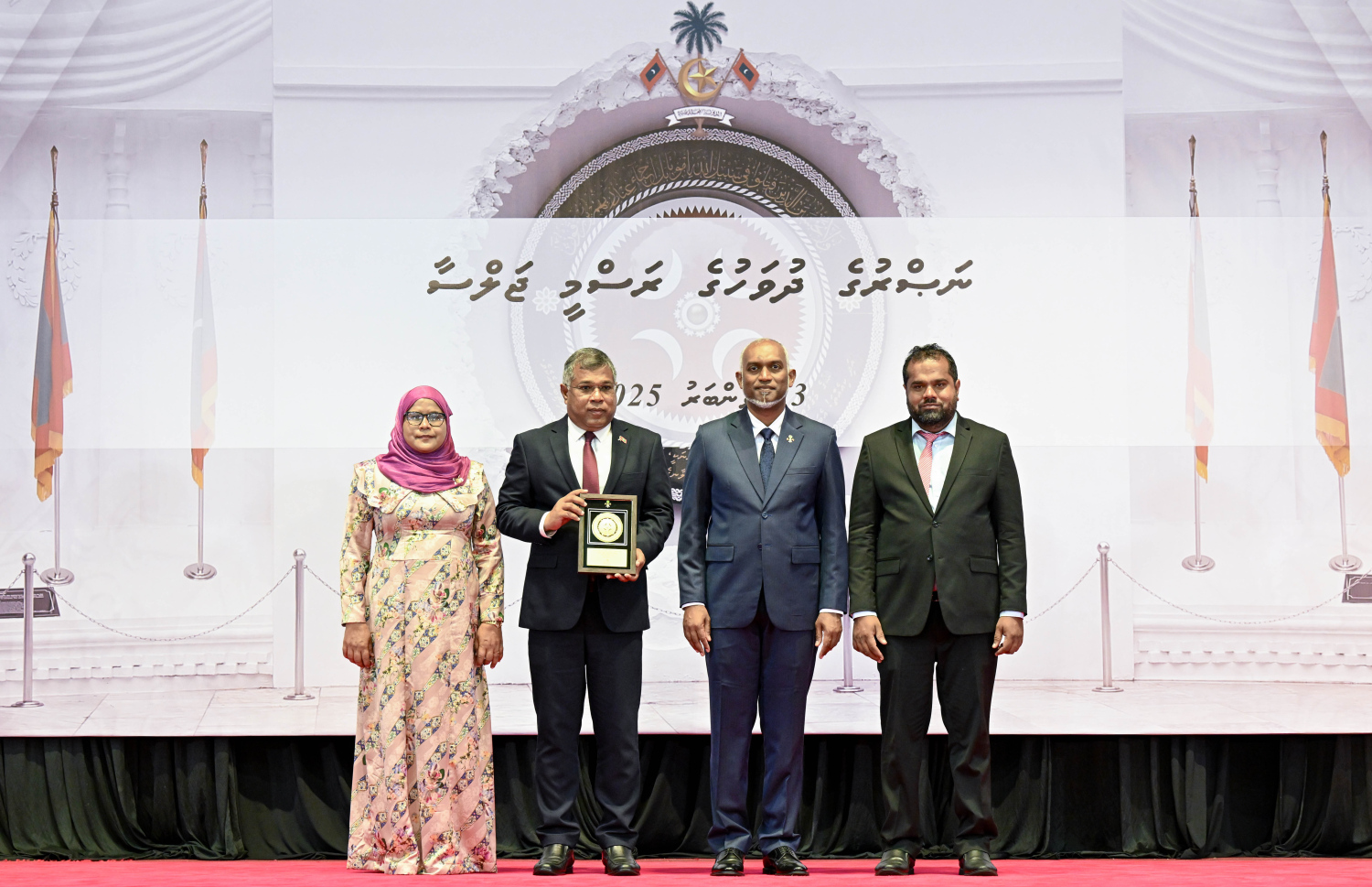 މި އަހަރުގެ ނަސްރުގެ ދުވަސް ފާހަގަކުރަން މިއަދު ބޭއްވި ރަސްމީ ޖަލްސާގައި، ނޮވެމްބަރު 3 ގެ ހަމަލާތަކުގައި ޝަހީދުވި މީހެއްގެ އާއިލާ އަށް ރައީސް. މުއިއްޒު އެރުވި އައްޑަނައާ އެކު، ފޮޓޯއަކަށް ހުއްޓިގެން.--- ފޮޓޯ: ރައީސް އޮފީސް