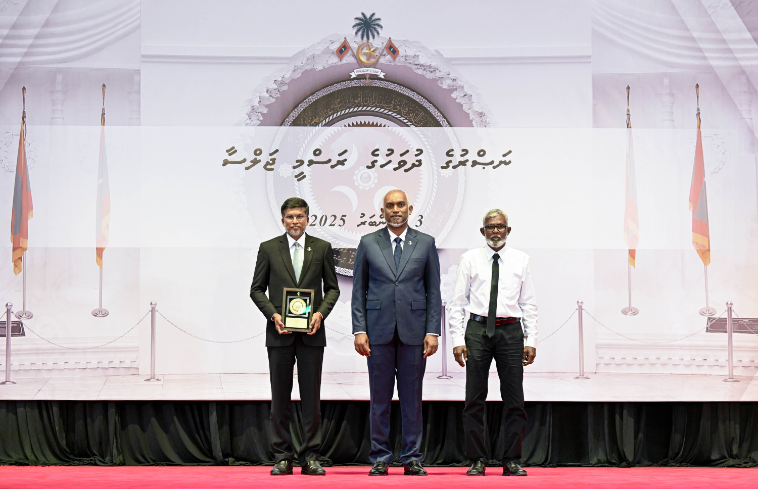 މި އަހަރުގެ ނަސްރުގެ ދުވަސް ފާހަގަކުރަން މިއަދު ބޭއްވި ރަސްމީ ޖަލްސާގައި، ނޮވެމްބަރު 3 ގެ ހަމަލާތަކުގައި ޝަހީދުވި މީހެއްގެ އާއިލާ އަށް ރައީސް. މުއިއްޒު އެރުވި އައްޑަނައާ އެކު، ފޮޓޯއަކަށް ހުއްޓިގެން.--- ފޮޓޯ: ރައީސް އޮފީސް