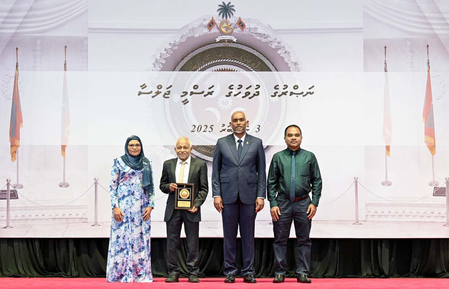 މި އަހަރުގެ ނަސްރުގެ ދުވަސް ފާހަގަކުރަން މިއަދު ބޭއްވި ރަސްމީ ޖަލްސާގައި، ނޮވެމްބަރު 3 ގެ ހަމަލާތަކުގައި ޝަހީދުވި މީހެއްގެ އާއިލާ އަށް ރައީސް. މުއިއްޒު އެރުވި އައްޑަނައާ އެކު، ފޮޓޯއަކަށް ހުއްޓިގެން.--- ފޮޓޯ: ރައީސް އޮފީސް