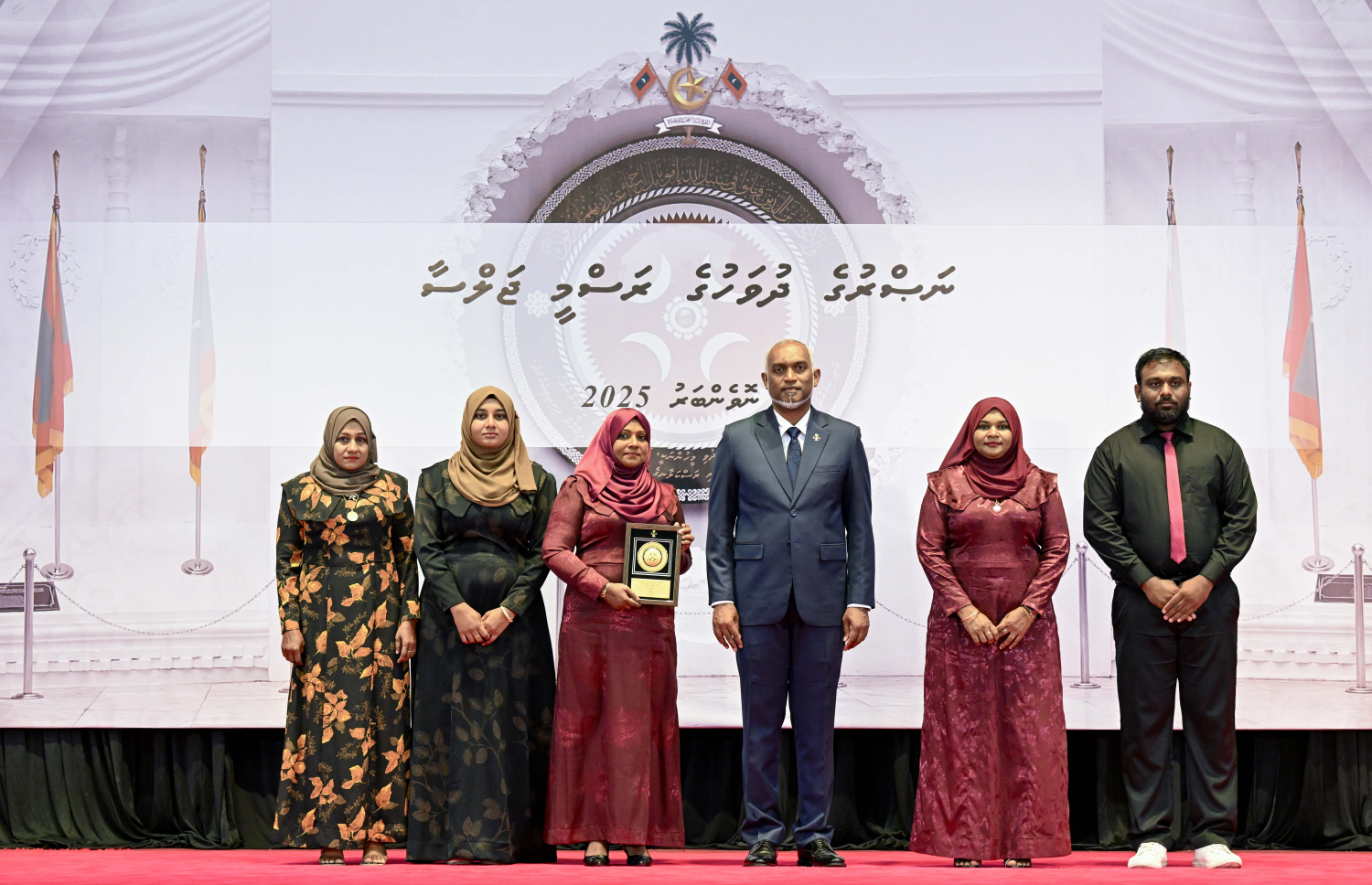 މި އަހަރުގެ ނަސްރުގެ ދުވަސް ފާހަގަކުރަން މިއަދު ބޭއްވި ރަސްމީ ޖަލްސާގައި، ނޮވެމްބަރު 3 ގެ ހަމަލާތަކުގައި ޝަހީދުވި މީހެއްގެ އާއިލާ އަށް ރައީސް. މުއިއްޒު އެރުވި އައްޑަނައާ އެކު، ފޮޓޯއަކަށް ހުއްޓިގެން.--- ފޮޓޯ: ރައީސް އޮފީސް