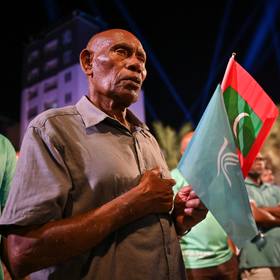 ސަރުކާރު ހިންގާ ޕާޓީ، ޕީއެންސީން މާލޭގެ އާޓިފިޝަލް ބީޗު ސަރަހައްދުގައި ބޭއްވި ބޮޑު ޖަލްސާ އަށް ދިޔަ ރައީސް މުއިއްޒުގެ ސަޕޯޓަރަކު ގައުމީ ދިދަ އާއި ޕީއެންސީގެ ދިދަ ހިފައިގެން ހުރެ ގައުމީ ސަލާން ކިޔަނީ.--- ފޮޓޯ: ފަޔާޒު މޫސާ | މިހާރު