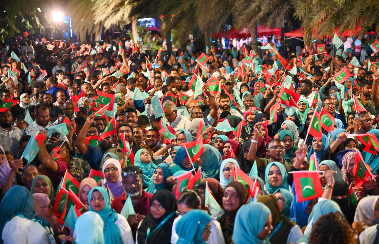 ސަރުކާރު ހިންގާ ޕާޓީ، ޕީއެންސީން މާލޭގެ އާޓިފިޝަލް ބީޗު ސަރަހައްދުގައި ބޭއްވި ބޮޑު ޖަލްސާގައި ބައިވެރިވި ގިނަ އަދަދެއްގެ ބަޔަކު ގައުމީ ދިދަ އާއި އެ ޕާޓީގެ ދިދަ ހިފައިގެން ތިބެ، ރައީސް މުއިއްޒަށް އޮތް ތާއީދު ހާމަކުރަނީ.--- ފޮޓޯ: ފަޔާޒު މޫސާ | މިހާރު