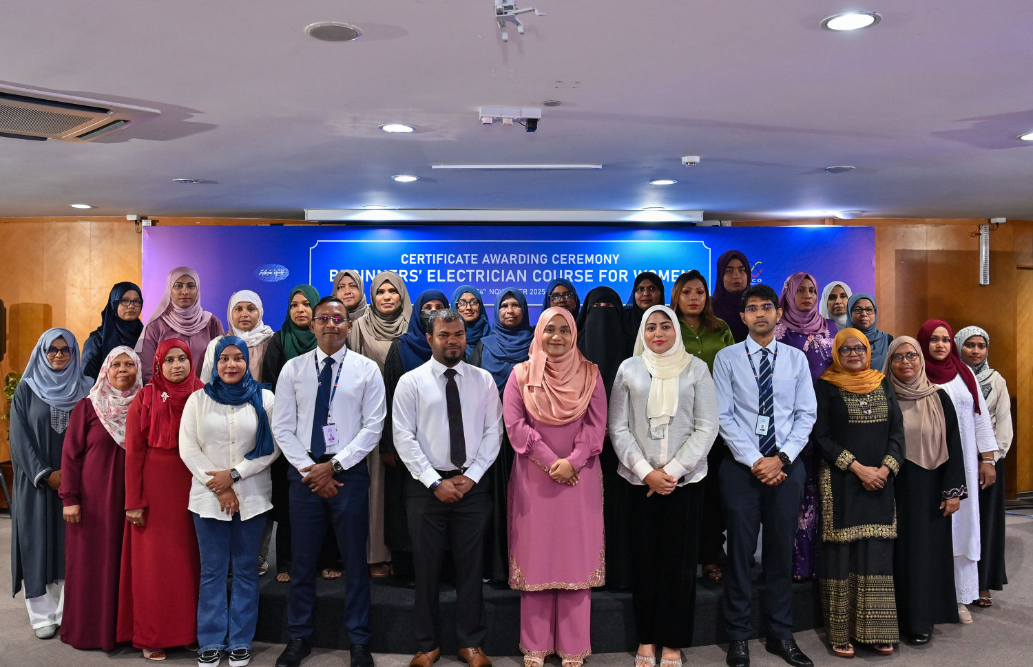 މާލެ: ނޮވެމްބަރު 24، 2025- އަންހެނުންނަށް ހާއްސަކޮށް ސްޓެލްކޯ އިން ބޭއްވި އިލެކްޓްރިޝަން ކޯސް ފުރިހަމަކުރި ބައެއް މީހުން ސެޓްފިކެޓު ދިނުމުގެ ހަފުލާ އަށް ފަހު، ފަސްޓް ލޭޑީ ސާޖިދާ އާއި އެ ކުންފުނީގެ ބައެއް އިސް ވެރިންނާ އެކު ފޮޓޯއެއް ނަގަނީ.---ފޮޓޯ: ރައީސް އޮފީސް