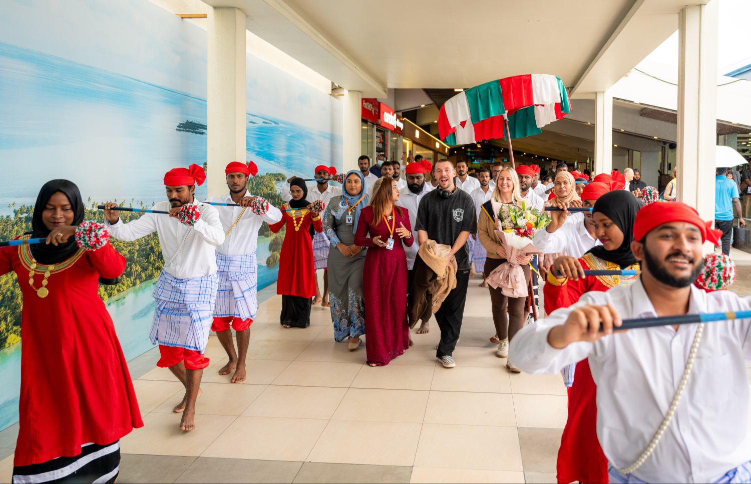 ރާއްޖެ އަށް ޒިޔާރަތްކުރި ދެ މިލިއަން ވަނަ ޓޫރިސްޓުގެ ޝަރަފު ހޯދި އިނގިރޭސި ވިލާތުގެ ބެތަނީ ސާރާ ކާސްވެލް އަށް ދިވެހި ސަގާފީ ހަރަކާތަކުން މަރުހަބާ ކިޔަނީ.---ފޮޓޯ: ނިޝާން އަލީ| މިހާރު