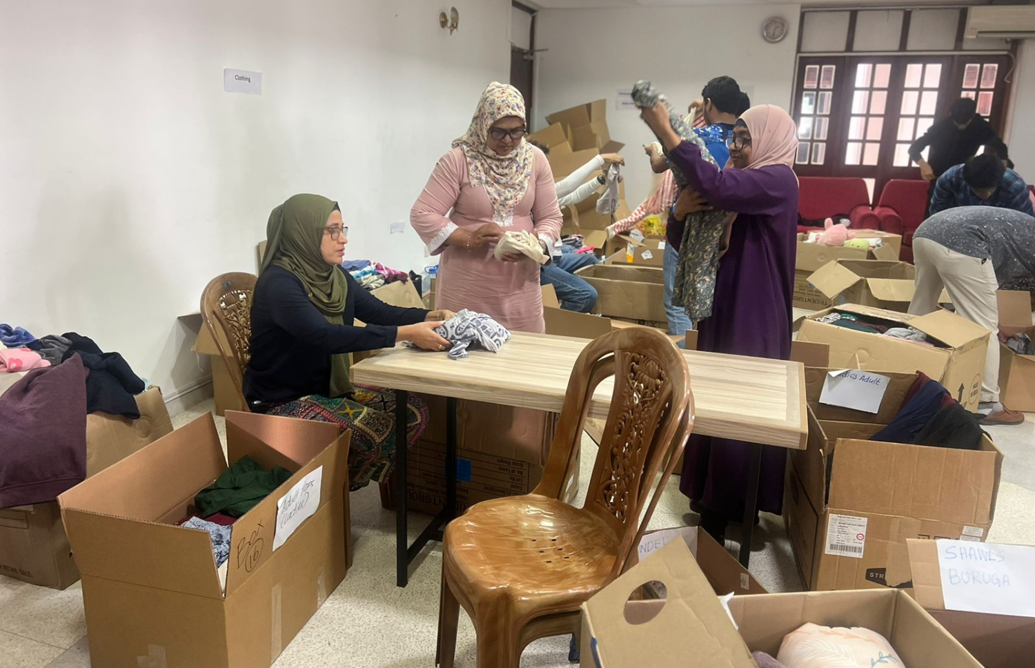 ލަންކާގައި އުޅޭ ދިވެހިން، އެ ގައުމުގައި ހާލުގައި ޖެހިފައިވާ މީހުންނަށް ދިނުމަށް އެއްކޮށްފައިވާ ބައެއް ސާމާނު ފޮށިތަކަށް އަޅަނީ. --  ފޮޓޯ: އަންވަރު