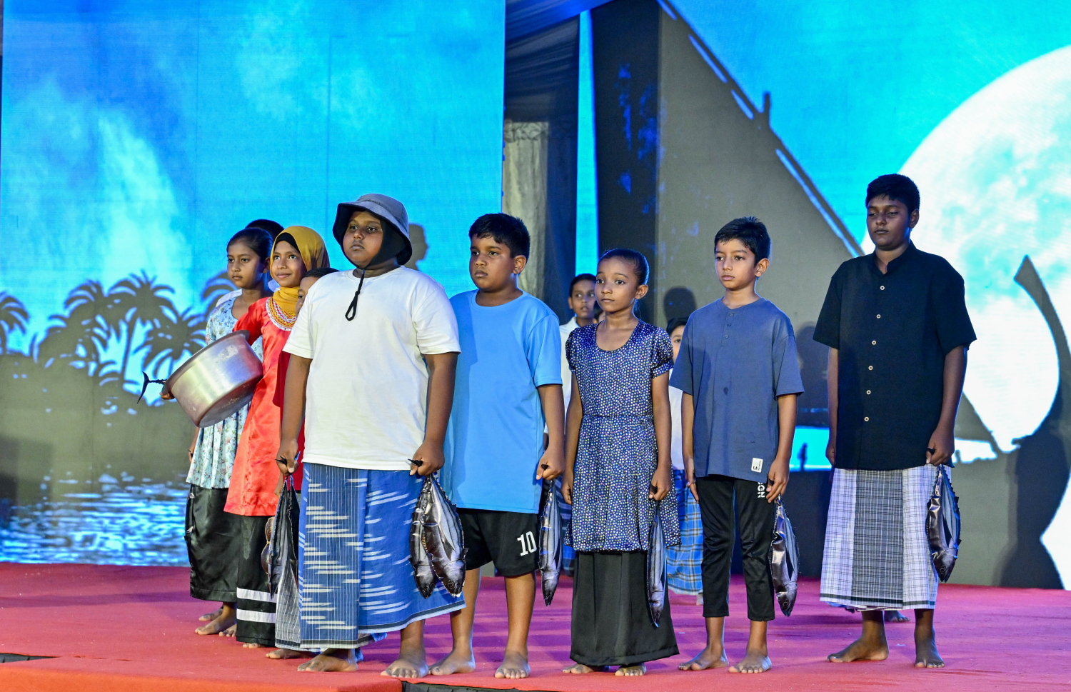 ރ. ދުވާފަރުގައި ރޭ ބޭއްވި މި އަހަރުގެ މަސްވެރިންގެ ދުވަހުގެ ރަސްމީ ޖަލްސާގައި ކުޑަކުދިން މުނިފޫހިފިލުވުމުގެ އައިޓަމެއް ހުށަހަޅައިދެނީ .-- ފޮޓޯ: ރައީސް އޮފީސް