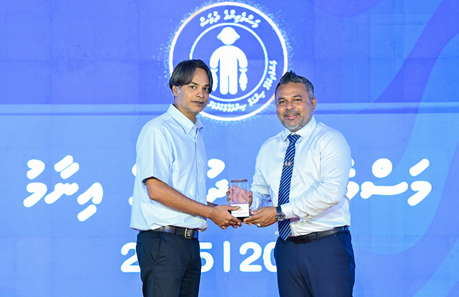 މަސްވެރިންގެ ދުވަސް ފާހަގަކުރަން ދުވާފަރުގައި ރޭ ބޭއްވި ޖަލްސާގައި މަސްވެރިއަކަށް މިނިސްޓަރު އަހްމަދު ޝިޔާމް އިނާމު ދެއްވަނީ.---ފޮޓޯ: ރައީސް އޮފީސް