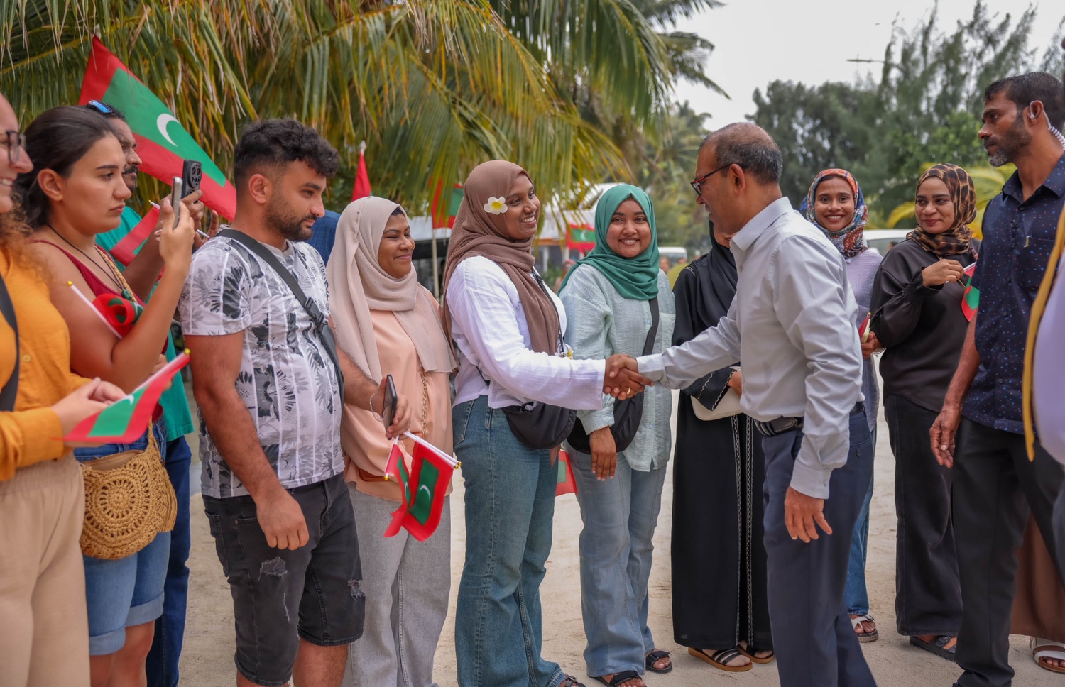 މާފުށީގެ ޓޫރިޒަމް ބްރޭންޑް "ހާޓް އޮފް މޯލްޑިވްސް" އިފްތިތާހުކުރުމަށް ކުރީގެ ރައީސް މުހައްމަދު ނަޝީދު އެ ރަށަށް ވަޑައިގަތުން މަރުހަބާ ކިޔަން ދިޔަ މީހަކާ އެމަނިކުފާނު ސަލާންކުރައްވަނީ.-- ފޮޓޯ: މާފުށި ކައުންސިލް