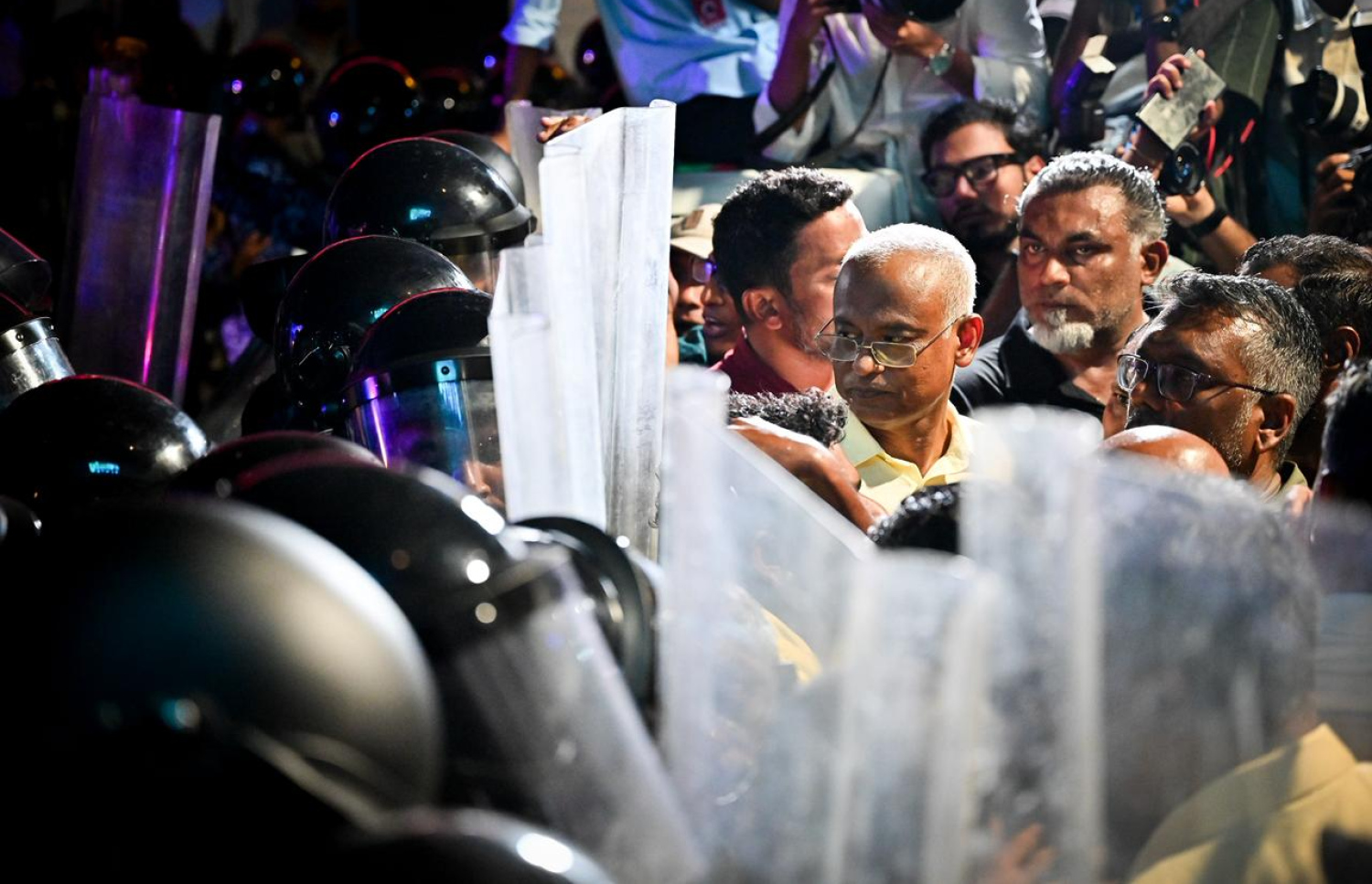 އޮކްޓޯބަރު 3، 2025: އިދިކޮޅު އެމްޑީޕީން ސަރުކާރާ ދެކޮޅަށް މާލޭގައި ބޭއްވި ބޮޑު އެއްވުމުގެ ބައިވެރިންނަށް މަޖީދީ މަގުން ކުރިއަށް ދާން ފުރުސަތު ނުލިބުމުން ކުރީގެ ރައީސް އިބްރާހިމް މުހައްމަދު ސޯލިހު ފުލުހުންގެ ޝީލްޑުތައް ކައިރީގައި މަޑުކޮށްލައްވައިގެން.--- ފޮޓޯ: ނިޝާން އަލީ| މިހާރު