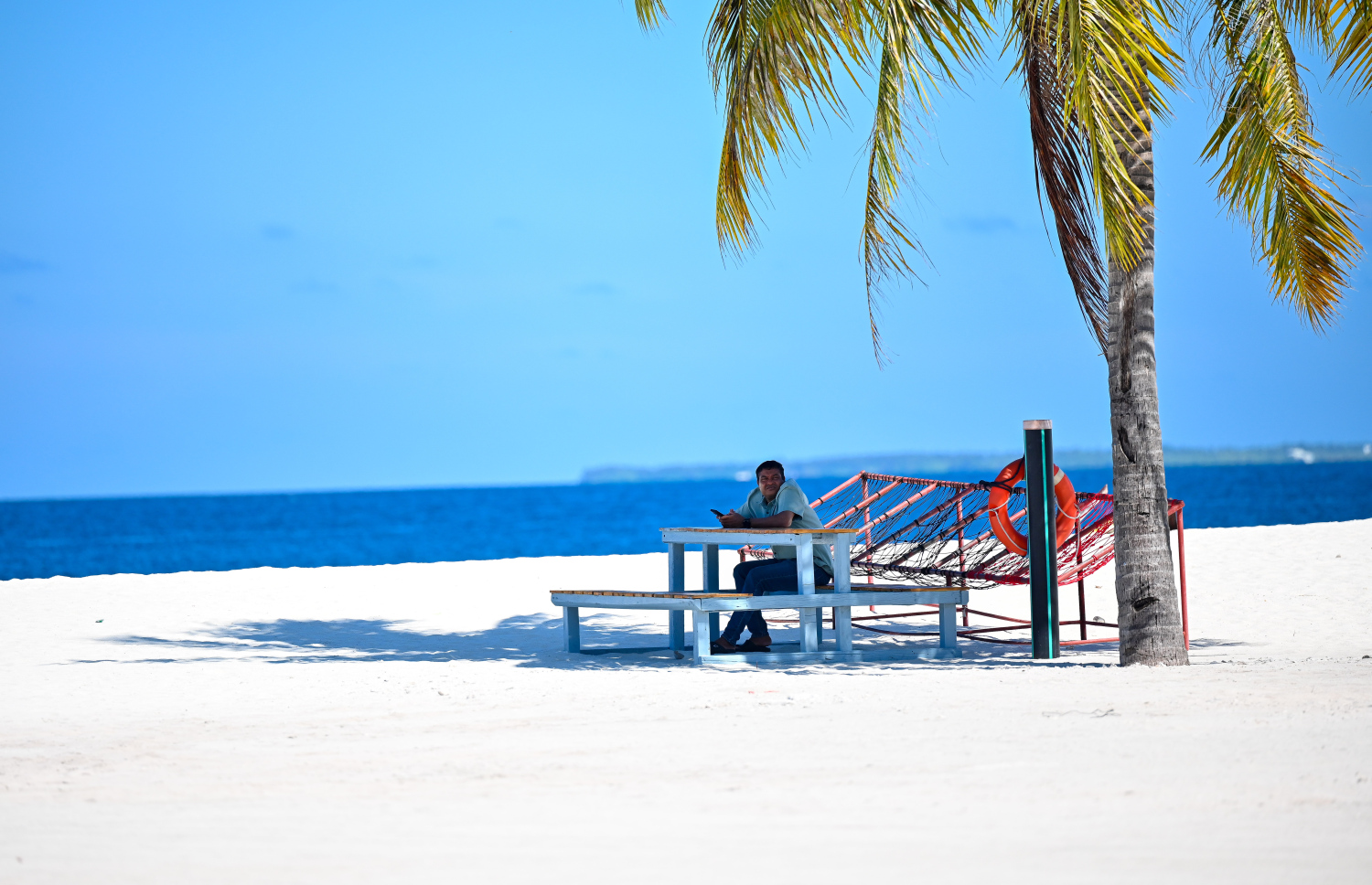 ހިރިމަރަދޫ ބަނދަރު ސަރަހައްދު ދިމާލު ބީޗުގައި ހުރި ޖޯލިފައްޗެއްގައި މީހަކު އިށީނދެލައިގެން. -- ފޮޓޯ: ފަޔާޒު މޫސާ | މިހާރު