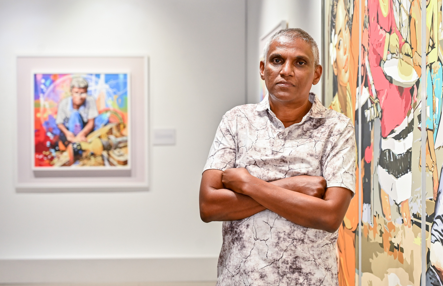 ކުރެހުންތެރިޔާ ހުސައިން އަލީ މަނިކުގެ "ވިވިޑް ރިއަލިޒަމް - ބައި ހުސައިން" އާޓް އެގްޒިބިޝަންގައި ކުރެހުންތައް ކައިރީ ފޮޓޯއަކަށް ހުއްޓިލައިގެން.-- ފޮޓޯ: ފަޔާޒު މޫސާ | މިހާރު