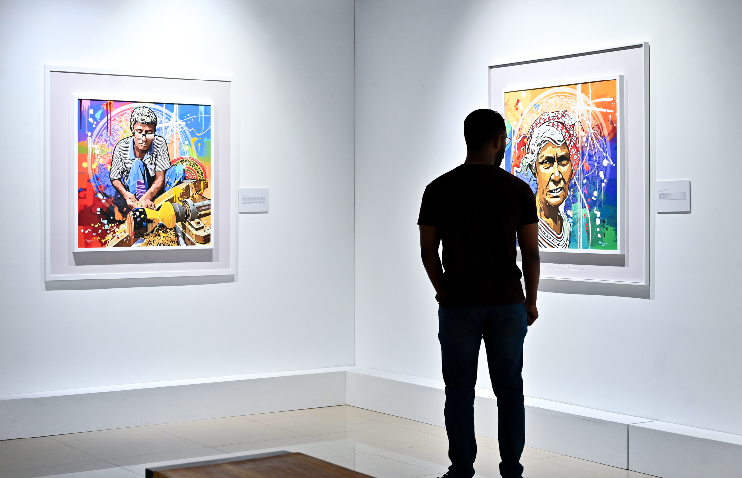 "ވިވިޑް ރިއަލިޒަމް - ބައި ހުސައިން" އާޓް އެގްޒިބިޝަނަށް ޒިޔާރަތްކުރި މީހަކު ކުރެހުންތެރިޔާ ހުސައިން އަލީ މަނިކުގެ ކުރެހުންތައް ބަލަނީ.-- ފޮޓޯ: ފަޔާޒު މޫސާ | މިހާރު