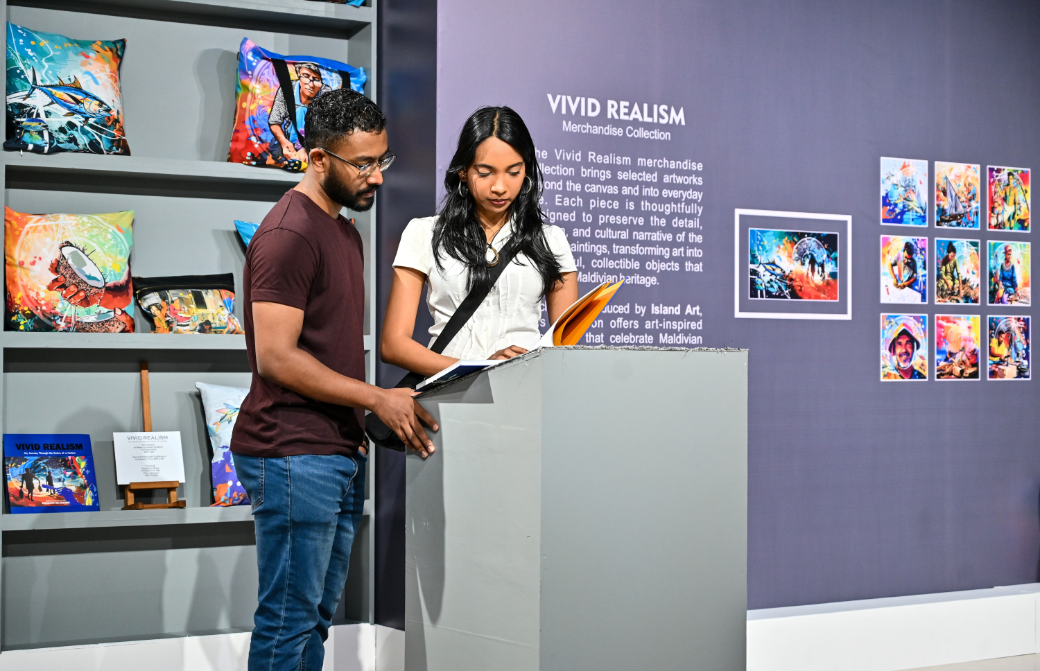 "ވިވިޑް ރިއަލިޒަމް - ބައި ހުސައިން" އާޓް އެގްޒިބިޝަނަށް ޒިޔާރަތްކުރި ބަޔަކު "ވިވިޑް ރިއަލިޒަމް – މައި ޖާނީ ތްރޫ ދަ ކަލާސް އޮފް އަ ނޭޝަން" ފޮތް ބަލައިލަނީ.-- ފޮޓޯ: ފަޔާޒު މޫސާ | މިހާރު