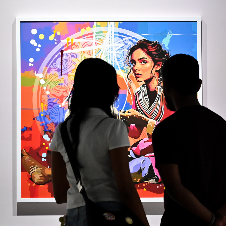 "ވިވިޑް ރިއަލިޒަމް - ބައި ހުސައިން" އާޓް އެގްޒިބިޝަނަށް ޒިޔާރަތްކުރި މީހަކު ކުރެހުންތެރިޔާ ހުސައިން އަލީ މަނިކުގެ ކުރެހުންތައް ބަލައިލަނީ.-- ފޮޓޯ: ފަޔާޒު މޫސާ | މިހާރު