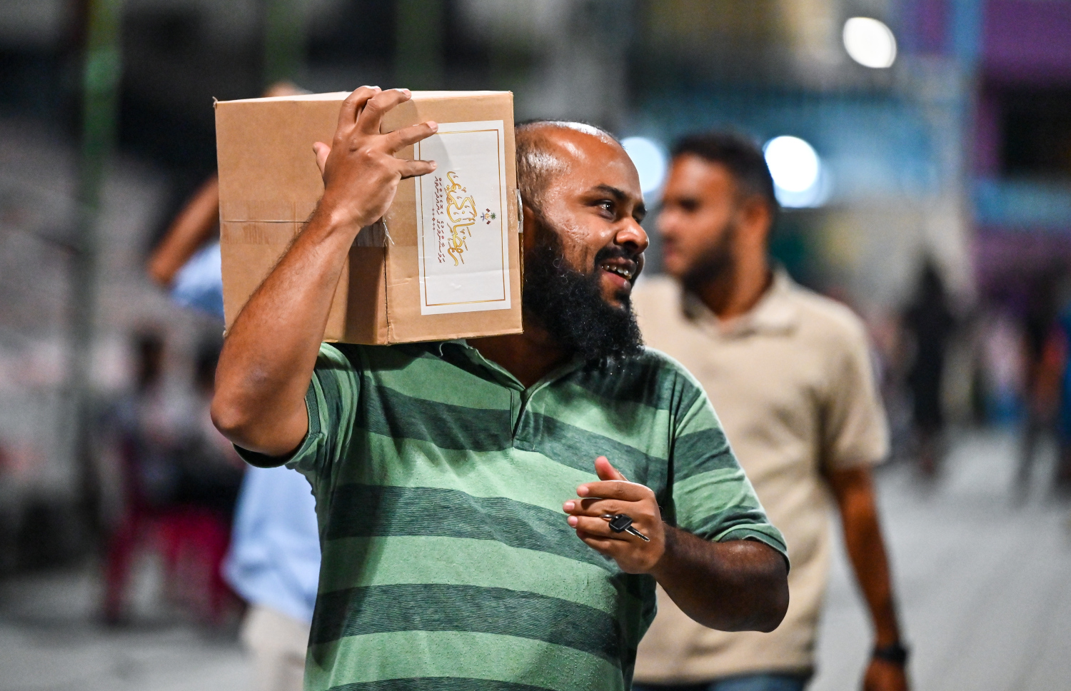 ކުރިއަށް އޮތް ރޯދަ މަހަށް ގޭބިސީތަކަށް ސަރުކާރުން ހަދިޔާކުރާ މަސްދަޅު ކޭސްތައް މާލެ ސަރަހައްދުން ދޫކުރަން ފެށުމުން މީހުން މަސްދަޅު ކޭހެއް ހިފައިގެން ދަނީ -- ފޮޓޯ: ފަޔާޒު މޫސާ | މިހާރު