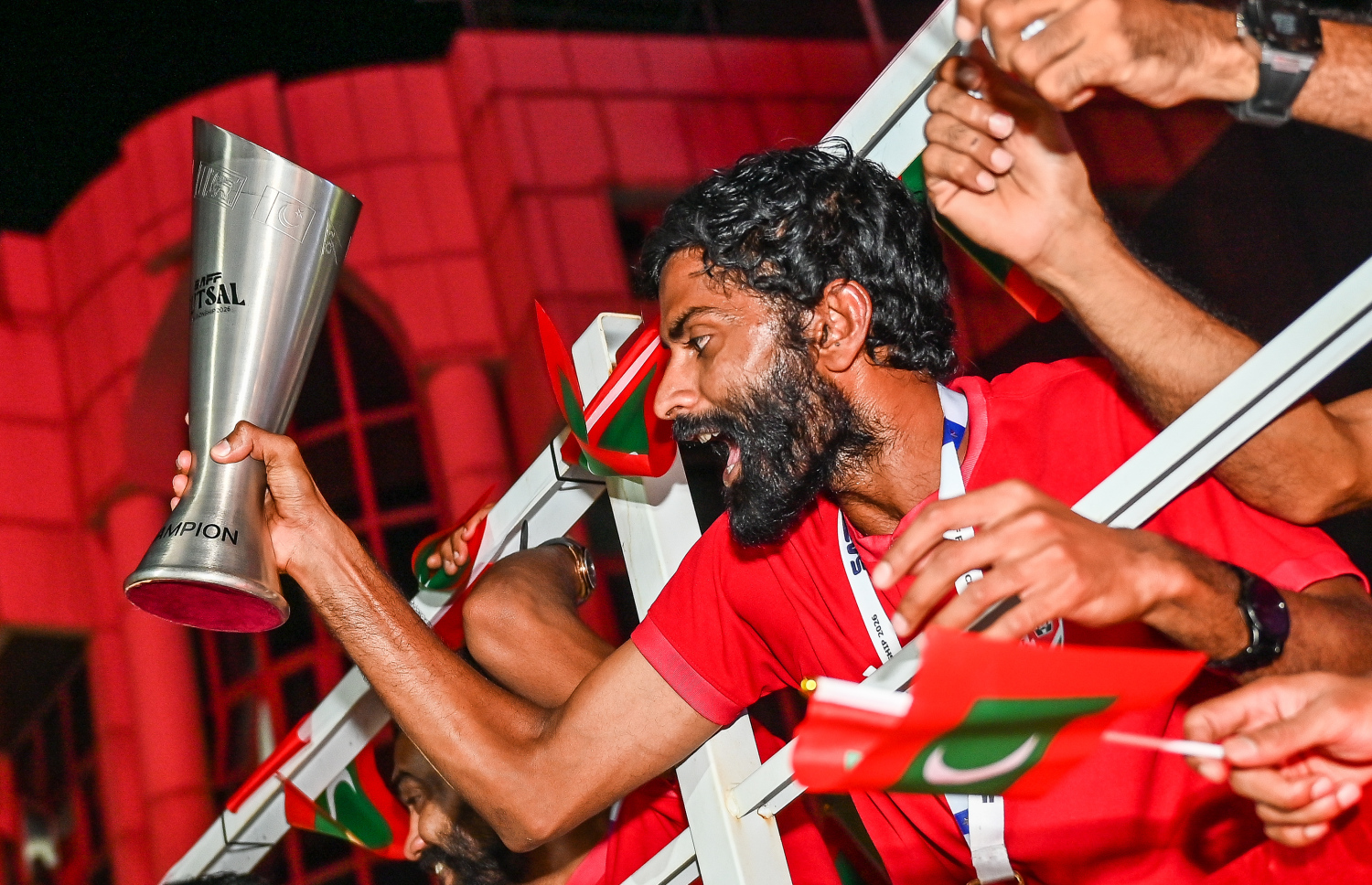 ދެކުނު އޭޝިއާގެ ފުޓްސަލް ޗެމްޕިއަންކަން ހޯދި ރާއްޖޭގެ ގައުމީ ފުޓްސަލް ޓީމު ރާއްޖެ އައުމުން، މަރުހަބާ ކިޔުމުގެ ގޮތުން ކުރިއަށް ގެންދިޔަ ލޮރީ ބުރުގައި، ޓީމުގެ ކުޅުންތެރިއަކު ތަށި ދައްކާލަނީ.-- ފޮޓޯ: ފަޔާޒު މޫސާ | މިހާރު