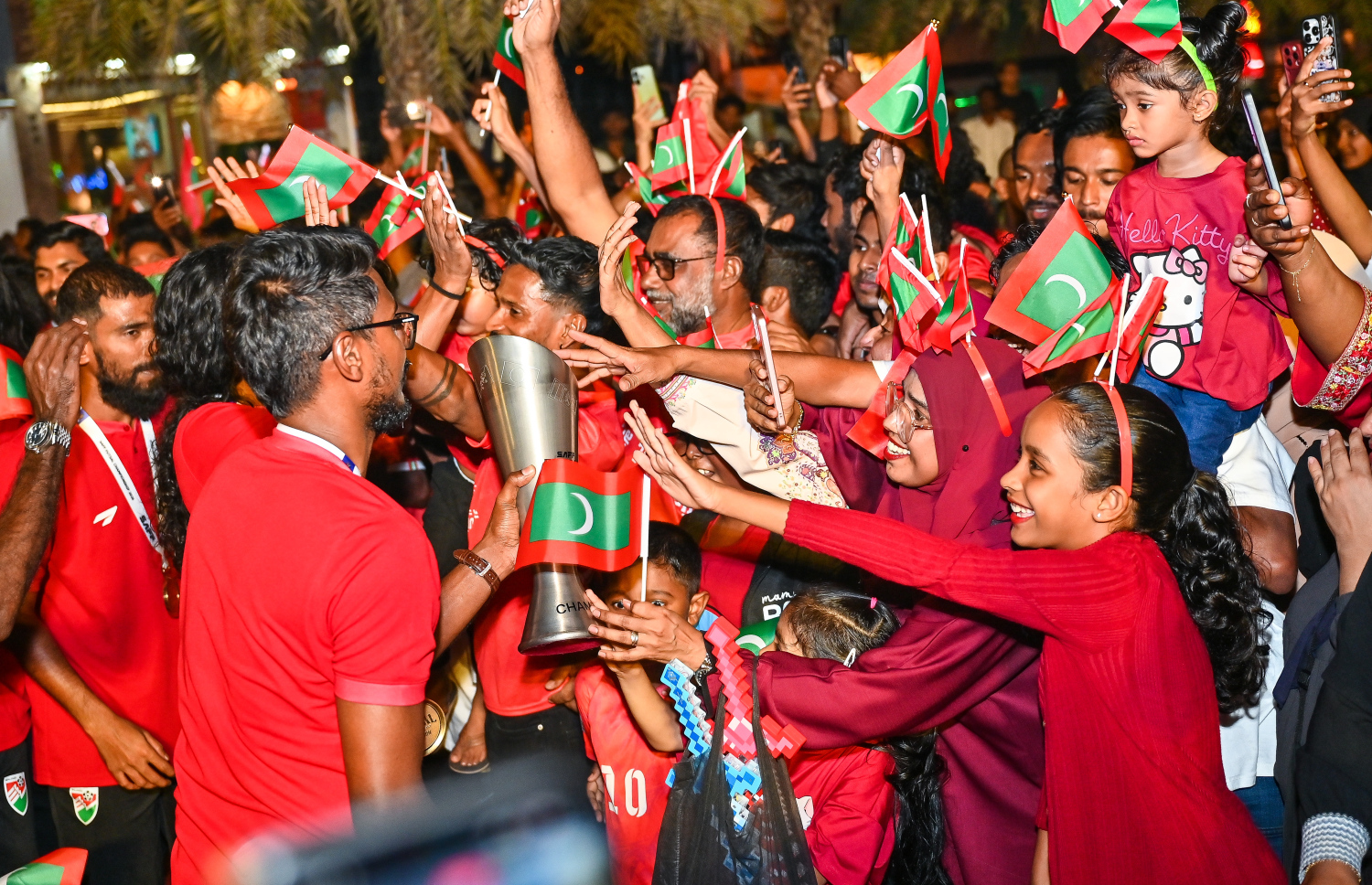 ފުޓްސަލް ޗެމްޕިއަންކަން ހޯދި ރާއްޖޭގެ ގައުމީ ފުޓްސަލް ޓީމު ތައްޓާ އެކު އާޓިފިޝަލް ބީޗަށް ވަނުމުން ކެޕްޓަން އިންމި އަށް ސަޕޯޓަރުން މަރުހަބާ ކިޔަނީ.-- ފޮޓޯ: ފަޔާޒު މޫސާ | މިހާރު