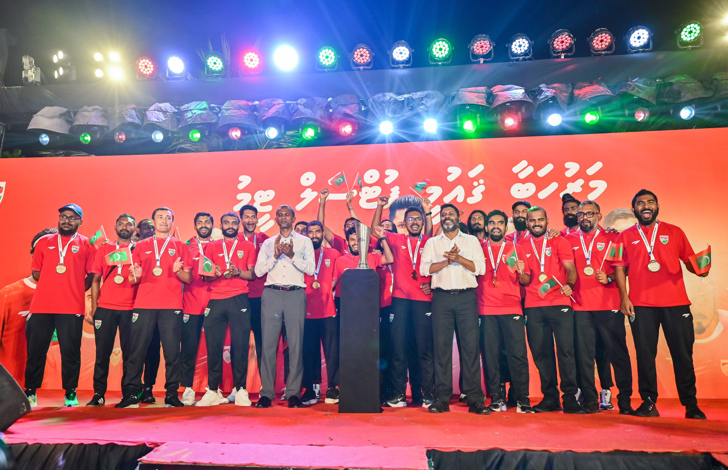 ސާފް ފުޓްސަލް މުބާރާތުގެ ތަށި ހުރިހާ މެޗަކުން މޮޅުވެ ހޯދި ރާއްޖޭގެ ގައުމީ ފުޓްސަލް ޓީމު ރާއްޖެ އައުމުން މަރުހަބާ ކިޔުމަށް ބޭއްވި އިވެންޓުގައި ޓީމާ އެކު، އެފްއޭއެމްގެ ރައީސް އަހުމަދު ތޯރިގް އާއި ސްޕޯޓްސް މިނިސްޓަރު އަބްދުﷲ ރާފިއު ގުރޫޕް ފޮޓޯއެއް ނަގަނީ.-- ފޮޓޯ: ފަޔާޒު މޫސާ | މިހާރު