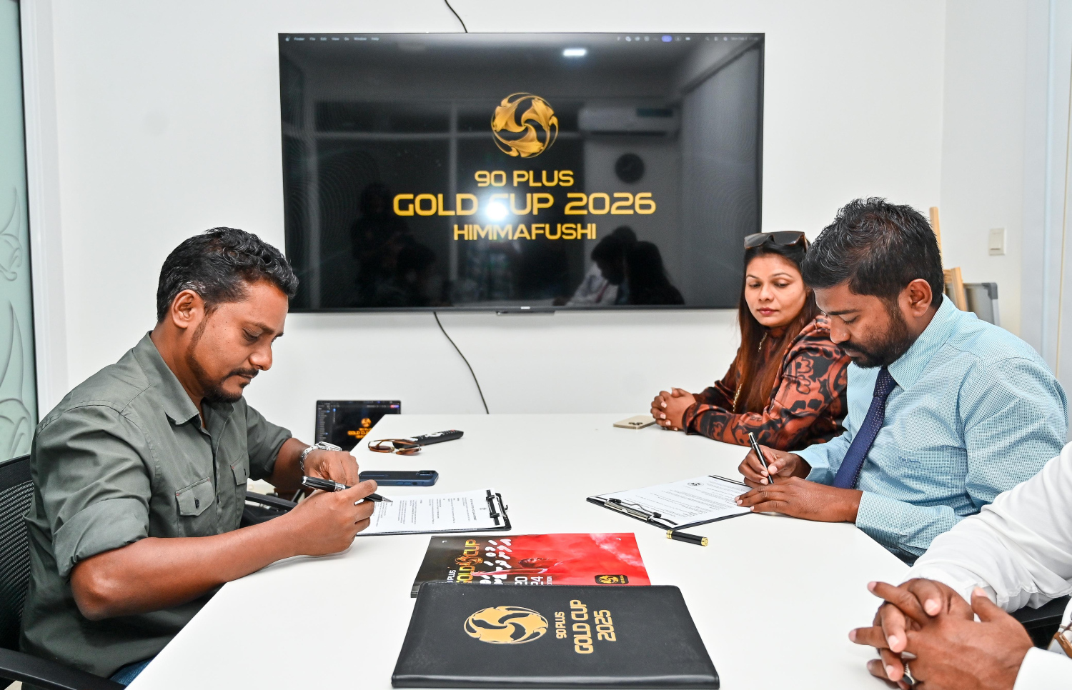 ގޯލްޑް ކަޕްގެ ދެވަނަ އެޑިޝަން ކ. ހިންމަފުށީގައި ބާއްވަން އިއުލާންކޮށް، އެ ރަށު ކައުންސިލާ އެކު ނައިންޓީ ޕްލަސްއިން އެއްބަސްވުމުގައި ސޮއިކުރަން ބޭއްވި ރަސްމިއްޔާތުގެ ތެރެއިން --- ފޮޓޯ: ފަޔާޒު މޫސާ | މިހާރު