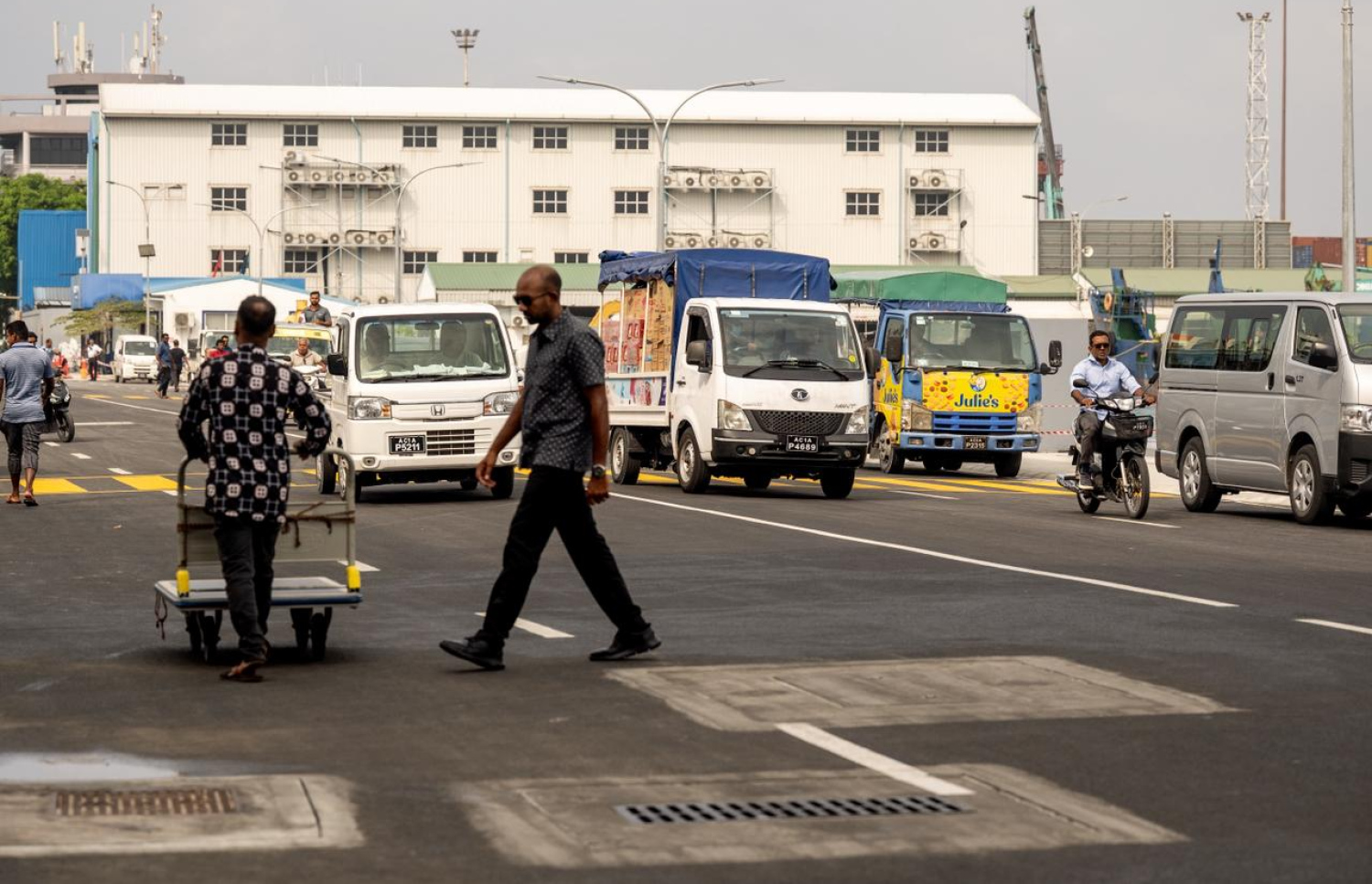 ބޮޑުތަކުރުފާނު މަގުގެ އަލަށް ހުޅުވި ސަރަހައްދުގައި ވެހިކަލް ދުއްވާއިރު މީހަކު މަގު ހުރަސްކުރަނީ. -- މިހާރު ފޮޓޯ/ނިޝާން އަލީ