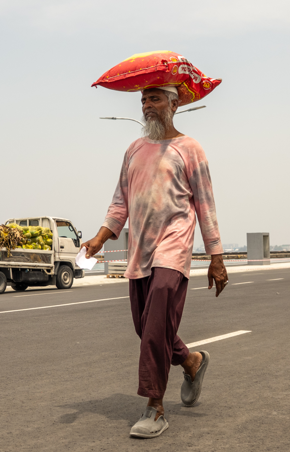 ލޯކަލް މާރުކޭޓު ކައިރިން މީހަކު ބޯމަތީ ހަނޑޫ ބަސްތާއެއް ގެންދަނީ.-- ފޮޓޯ: ނިޝާން އަލީ | މިހާރު