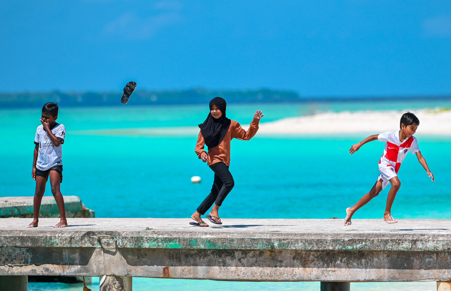 މޫދަށް އެރުމަށާއި ޑިންގީ ލަފާ ފޭބުމަށް ނޮޅިވަރަންފަރު ބީޗުގައި ހަދާފައިވާ ޖެޓީގައި ކުދިންތަކެއް ސަކަރާތް ޖަހަނީ -- ފޮޓޯ: ފަޔާޒު މޫސާ | މިހާރު