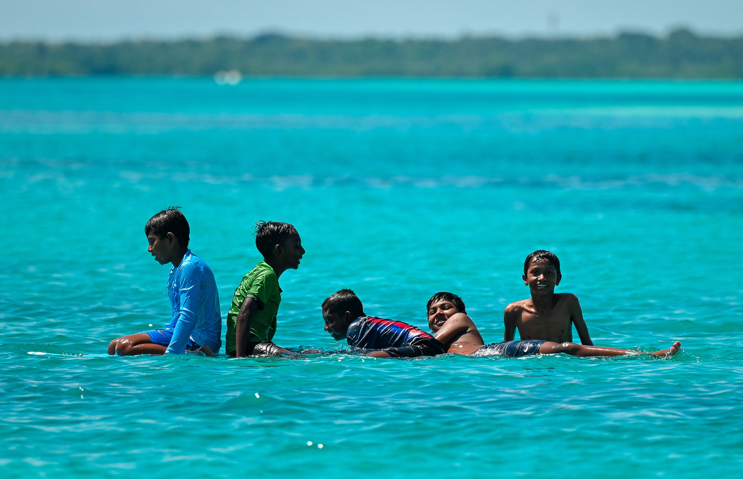 ކުދިންތައް މޫދަށް އެރި މަޖާކުރަނީ. ބަންދު ދުވަސްތަކުގައި އާއިލާއާ އެކު ގިނަ އަދަދެއްގެ ކުދިން މޫދަށް އެރެން މި ބީޗަށް އާދޭ -- ފޮޓޯ: ފަޔާޒު މޫސާ | މިހާރު