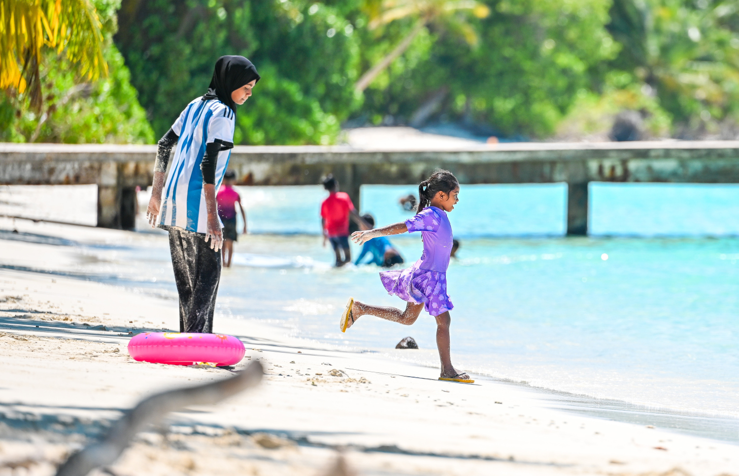 ކުޑަކުއްޖަކު އާއިލާގެ މީހުންނާ އެކު ބީޗުގައި ކުޅެނީ. ހދ. ނޮޅިވަރަންފަރަކީ އަޖައިބުކުރަނިވި ރީތިކަމެއް ލިބިފައިވާ ބިން ބޮޑު ރަށެއް -- ފޮޓޯ: ފަޔާޒު މޫސާ | މިހާރު