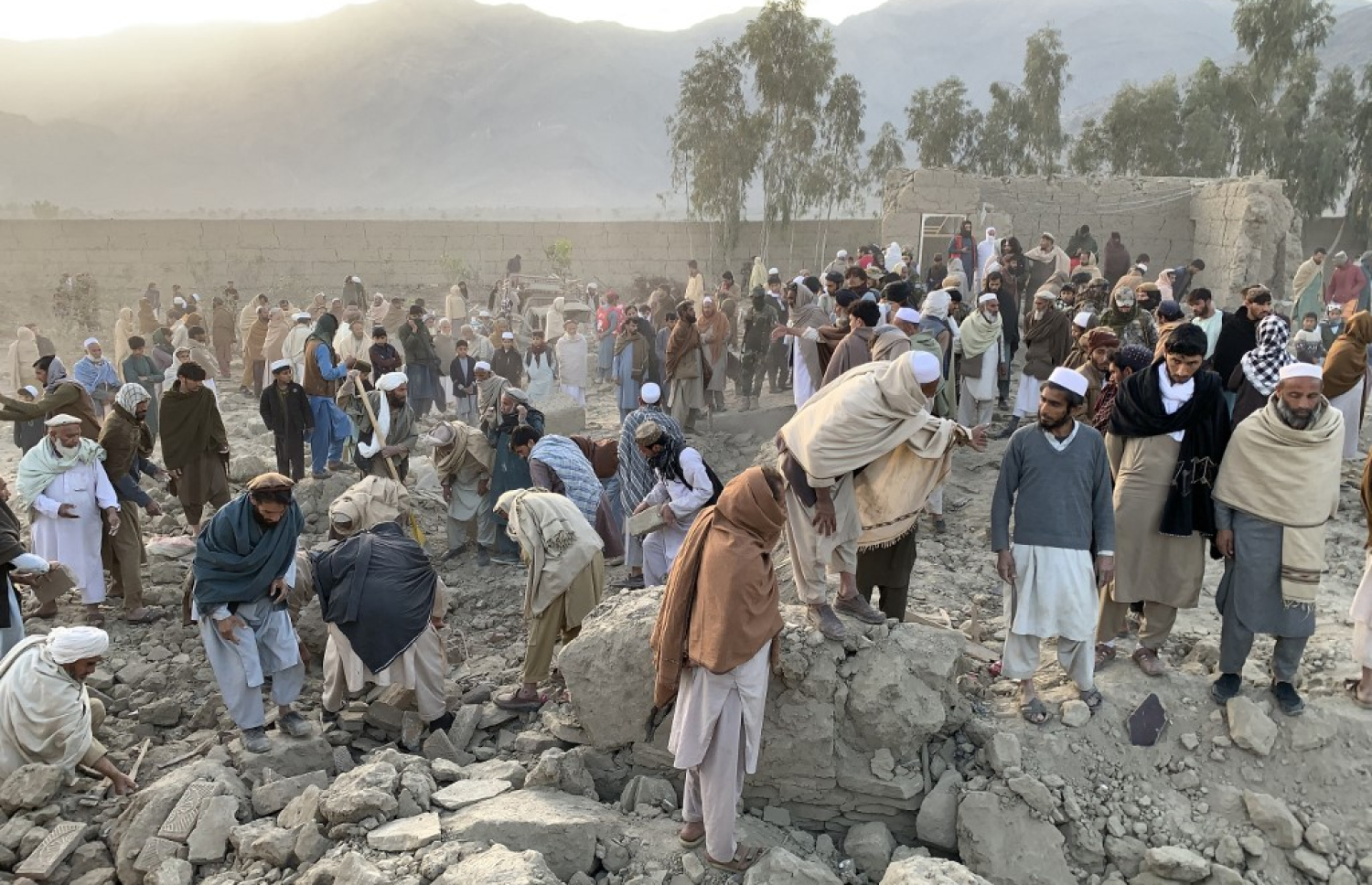 އާދީއްތަ ދުވަހު ޕާކިސްތާނުން އަފްޣާނިސްތާނަށް ދިން ހަމަލާތަކުގައި ހަލާކުވެފައިވާ ތަނެއްގެ ކައިރިއަށް ބަޔަކު ޖަމާވެފައި. -- ފޮޓޯ: އޭއެފްޕީ