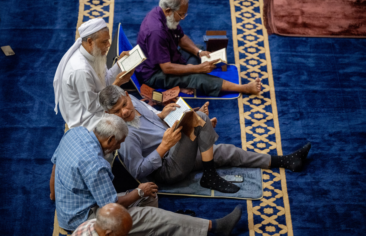 ޖަމާއަތުގައި ކުރި މެންދުރު ނަމާދަށް ފަހު، ބަޔަކު އިސްލާމީ މަރުކަޒުގައި ގުރުއާން ކިޔަވަނީ: ރޯދަމަހުގެ ސަވާބާއި ދަރުމަ ހޯދަން މިސްކިތްތަކުގައި މީހުން ވަގުތު ހޭދަކުރާ މިންވަރު ވަރަށް ބޮޑަށް އިތުރުވޭ.-- ފޮޓޯ: ނިޝާން އަލީ | މިހާރު