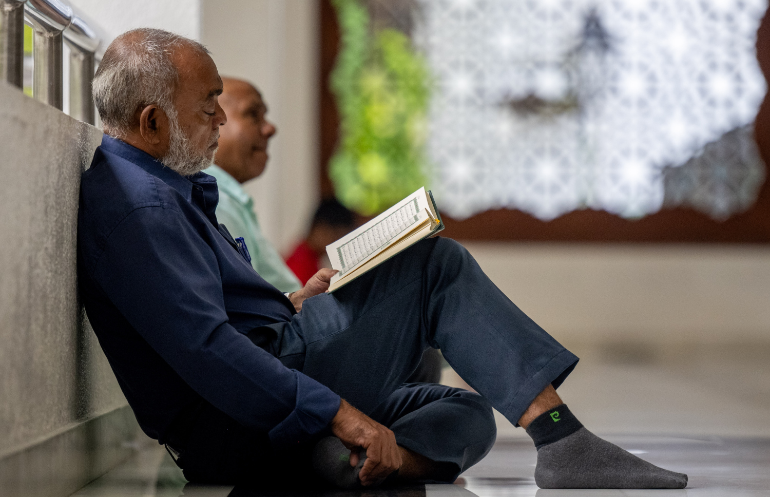 ޖަމާއަތުގައި ކުރި މެންދުރު ނަމާދަށް ފަހު، ބަޔަކު ގުރުއާން ކިޔަވަނީ: ރޯދަމަހުގެ ސަވާބާއި ދަރުމަ ހޯދަން މިސްކިތްތަކުގައި މީހުން ވަގުތު ހޭދަކުރާ މިންވަރު ވަރަށް ބޮޑަށް އިތުރުވޭ.-- ފޮޓޯ: ނިޝާން އަލީ | މިހާރު