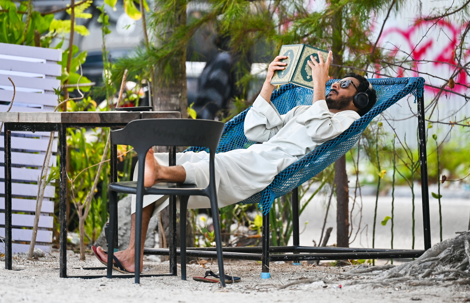 ރޯދަ ކުރުކުރުމުގެ ގޮތުން މީހަކު ހުޅުމާލެ ބީޗުގައި ހުރި ޖޯއްޔެއްގައި ޤުރުއާން ކިޔަވަނީ --- މިހާރު ފޮޓޯ/ފަޔާޒު މޫސާ