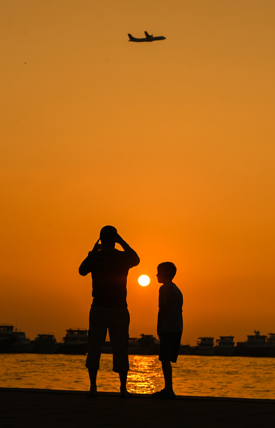 މިއަދު އިރުއޮއްސުނު ވަގުތު ކުޑަކައްޖަކާއި މީހަކު ހުޅުމާލެ ލަކުޑި ޖެޓީ ސަރަހައްދުގައި އިރުއޮއްސޭ މަންޒަރު ފޮޓޯ ނަގަނީ --- މިހާރު ފޮޓޯ/ފަޔާޒު މޫސާ