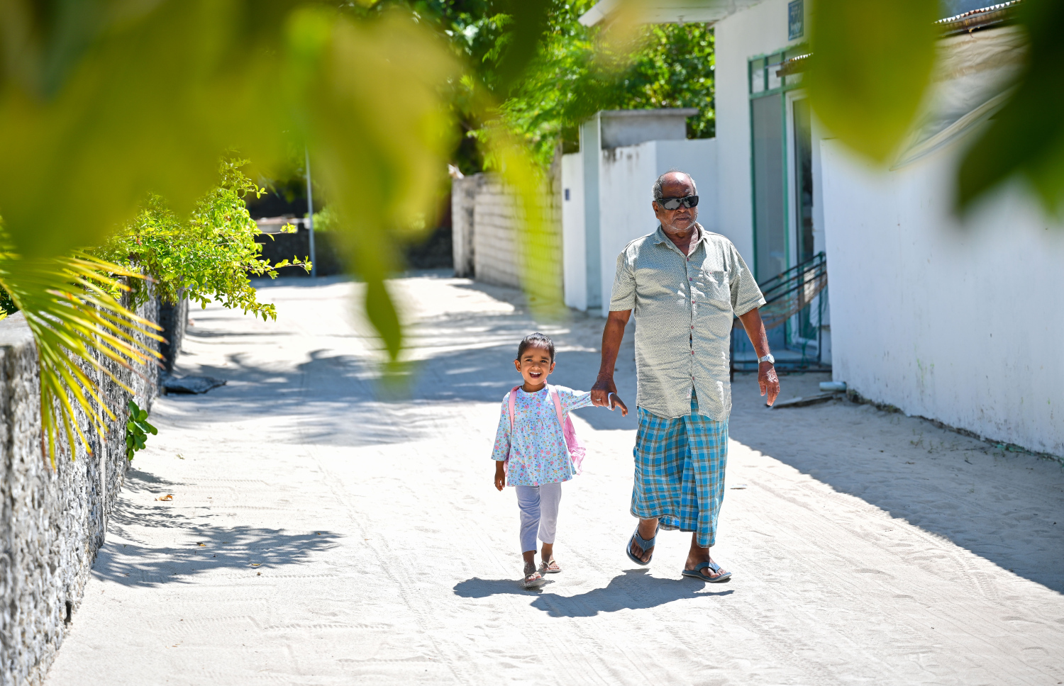 އުތީމުގެ އުމުރުން ދުވަސްވީ މީހަކު ކުޑަކުއްޖަކު ގޮވައިގެން މަގުމަތިން ހިނގާފައި ދަނީ --- މިހާރު ފޮޓޯ/ފަޔާޒް މޫސާ