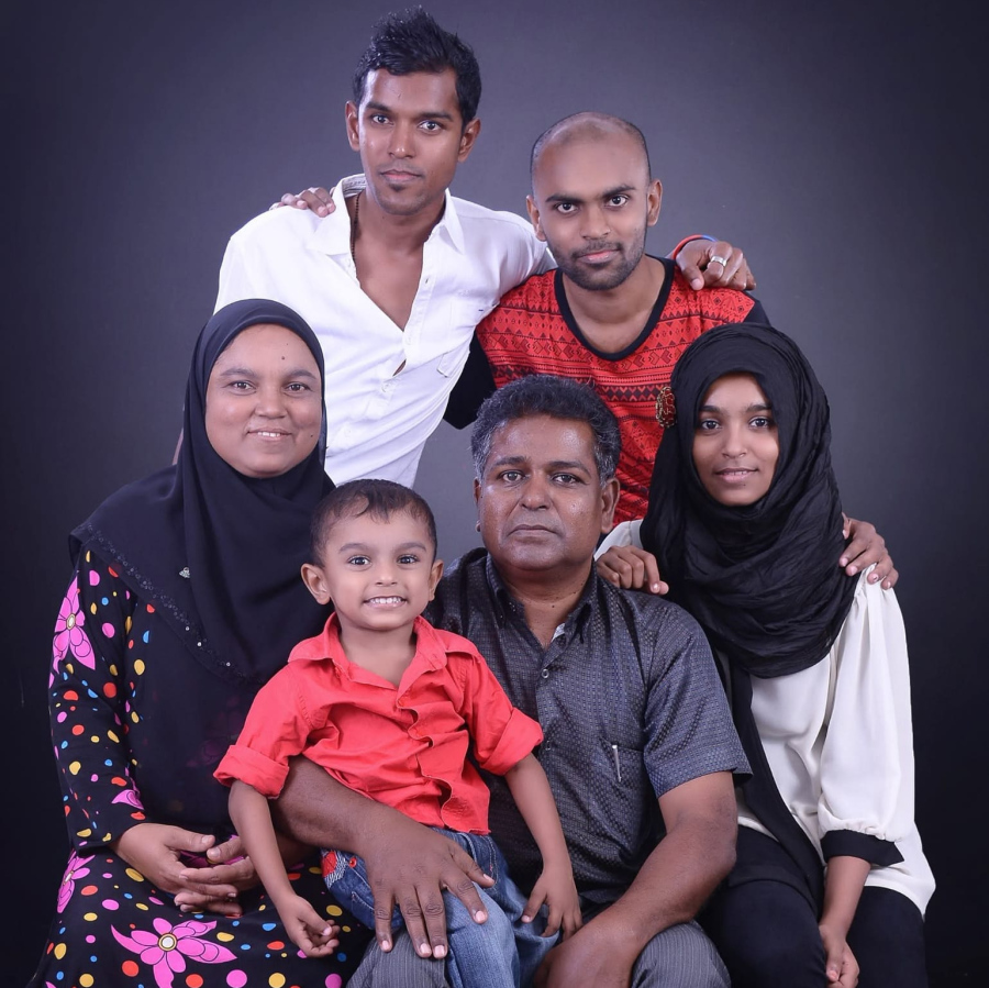 މުއާޒުގެ މަންމަ އާއި ބައްޕަ އަދި އެއްބަނޑުއެއްބަފާ ތިން މީހުންނާއެކު ފޮޓޯއެއް ނަގަނީ. ޖަމީލް އަދި އަބްދުﷲ މުއާޒު މާލޭގައި ދިރިއުޅޭތީ ރެސްޓޯރެންޓު ހިންގުމުގައި އިސްކޮށް އުޅެނީ އަލީ މުއާޒު.