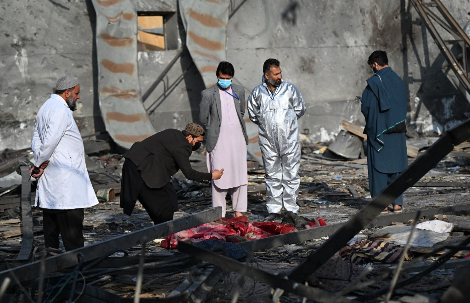 ޕާކިސްތާނުން ހަމަލާދިން ތަނުން މަރުވި މީހެއްގެ ހަށިގަނޑު ކައިރީ ބަޔަކު މަޑުކޮށްލައިގެން. -- ފޮޓޯ: އޭއެފްޕީ