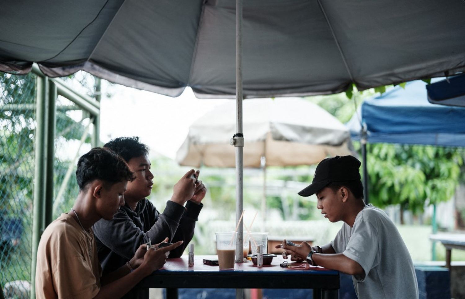 އިންޑޮނީޝިއާގެ ކެފޭއެއްގައި ބަޔަކު މަޑުކޮށްލައިގެން ތިބި އިރު ފޯނުން ސޯޝަލް މީޑިއާ ބޭނުންކުރަނީ. -- ފޮޓޯ: އޭއެފްޕީ