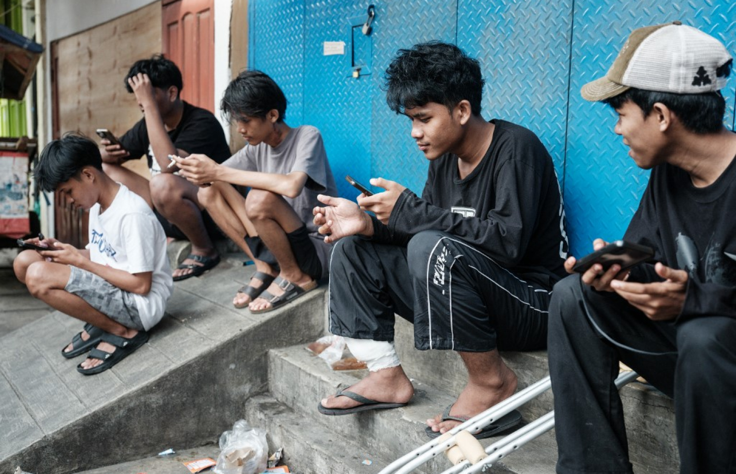 އިންޑޮނީޝިއާގައި ކުދިންތަކެއް މަގުމަތީގައި އިށީނދެ ތިބެގެން ސޯޝަލް މީޑިއާ ބޭނުންކުރަނީ. -- ފޮޓޯ: އޭއެފްޕީ