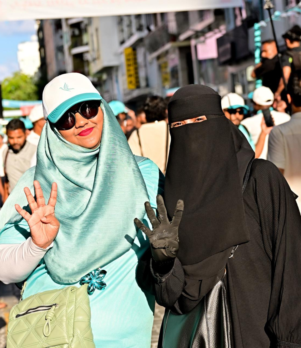 ސަރުކާރު ހިންގާ ޕާޓީ ޕީއެންސީގެ ލޯކަލް ކައުންސިލް އިންތިހާބުގެ ކެމްޕެއިން ނިންމާލުމަށް ބޭއްވި ހިނގާލުމުގައި އެ ޕާޓީގެ ހަރަކާތްތަކުގައި ކުރީ ސަފުގައި އުޅުއްވާ ޝިއުނާ އާއި މަލްޝާ.-- ފޮޓޯ: ނިޝާން އަލީ | މިހާރު