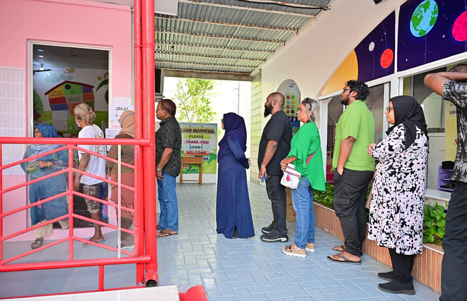 ވޯޓްލާ މަރުކަޒެއްގެ ކައިރީގައި ބަޔަކު ކިއުގައި މަޑުކޮށްލައިގެން --- މިހާރު ފޮޓޯ/ނިޝާން އަލީ