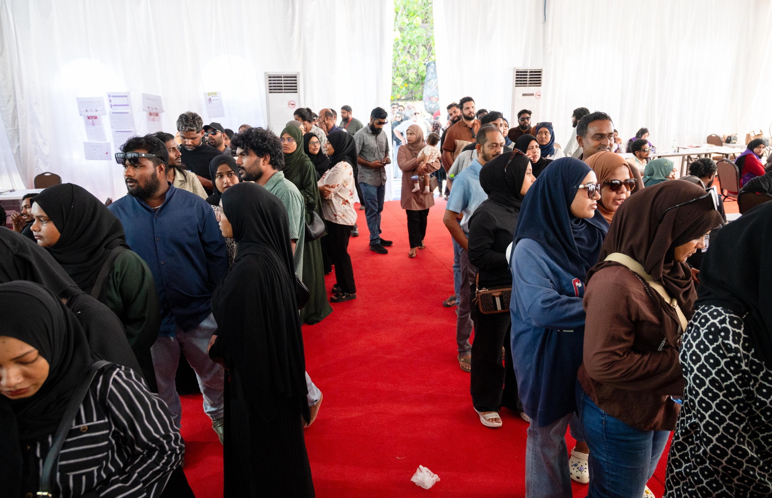 ލޯކަލް ކައުންސިލް އިންތިހާބު 2026: މާފަންނު ސްޓޭޑިއަމްގައި ހުރި ޓެންޓުގައި ބަހައްޓާފައިވާ ވޯޓުފޮށްޓަކަށް ވޯޓުލުމަށް ގިނަ ބަޔަކު ކިއުގައި ޖެހިގެން.-- ފޮޓޯ: ފަޔާޒް މޫސާ | މިހާރު