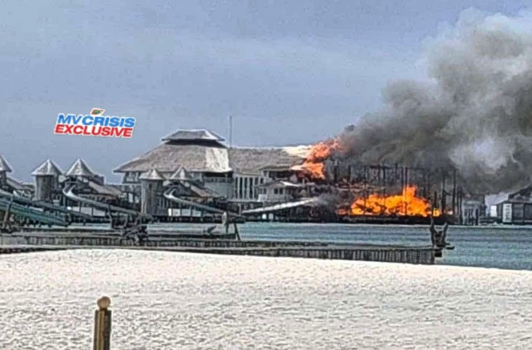 Una vista aérea de una estructura sobre el agua en el resort Soneva Jani en Maldivas con columnas de humo visibles