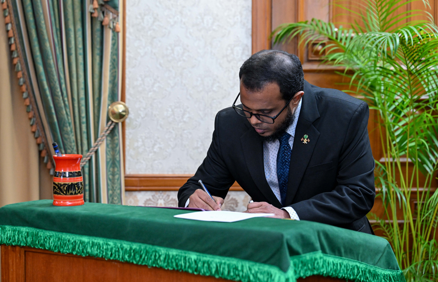 ކްލައިމެޓް ޗޭންޖް، އެންވަޔަރަންމަންޓް އެންޑް އެނާޖީ މިނިސްޓަރުކަމަށް އައްޔަންކުރެއްވި އަލީ ޝަރީފް ހުވާގެ އިގުރާރުގައި ސޮއިކުރައްވަނީ.--- ފޮޓޯ: ރައީސް އޮފީސް