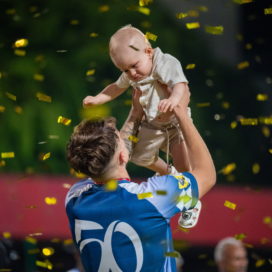 ފައިނަލުގައި ޓީސީ ސްޕޯޓްސްގެ މައްޗަށް 3-0 ގެ ނަތީޖާއަކުން ކާމިޔާބު ހޯދައި، އެފްއޭ ކަޕްގެ ޗެމްޕިއަންކަން ހޯދި ނިއު ރޭޑިއަންޓުގެ ބޭރު ކުޅުންތެރިޔާ ލޫއިސް ގޯމެސް ޑާ ސިލްވާ ދަރިފުޅާ އެކު އުފާ ފާޅުކުރަނީ.-- ފޮޓޯ: ފަޔާޒު މޫސާ | މިހާރު