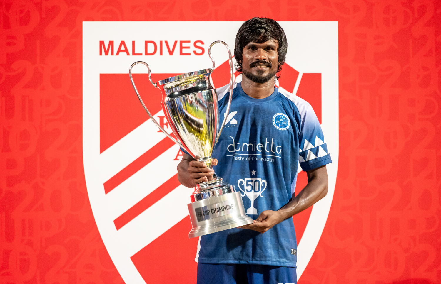 އެފްއޭ ކަޕް ޗެމްޕިއަންކަން ހޯދުމަށް ފަހު ނިއު ރޭޑިއަންޓުގެ ޑިފެންޑަރު މުހައްމަދު ނިޒާމް (ޕީކޭ) ތައްޓާއެކު ފޮޓޯއަކަށް ހުއްޓިލައިގެން.-- ފޮޓޯ: ފަޔާޒު މޫސާ | މިހާރު