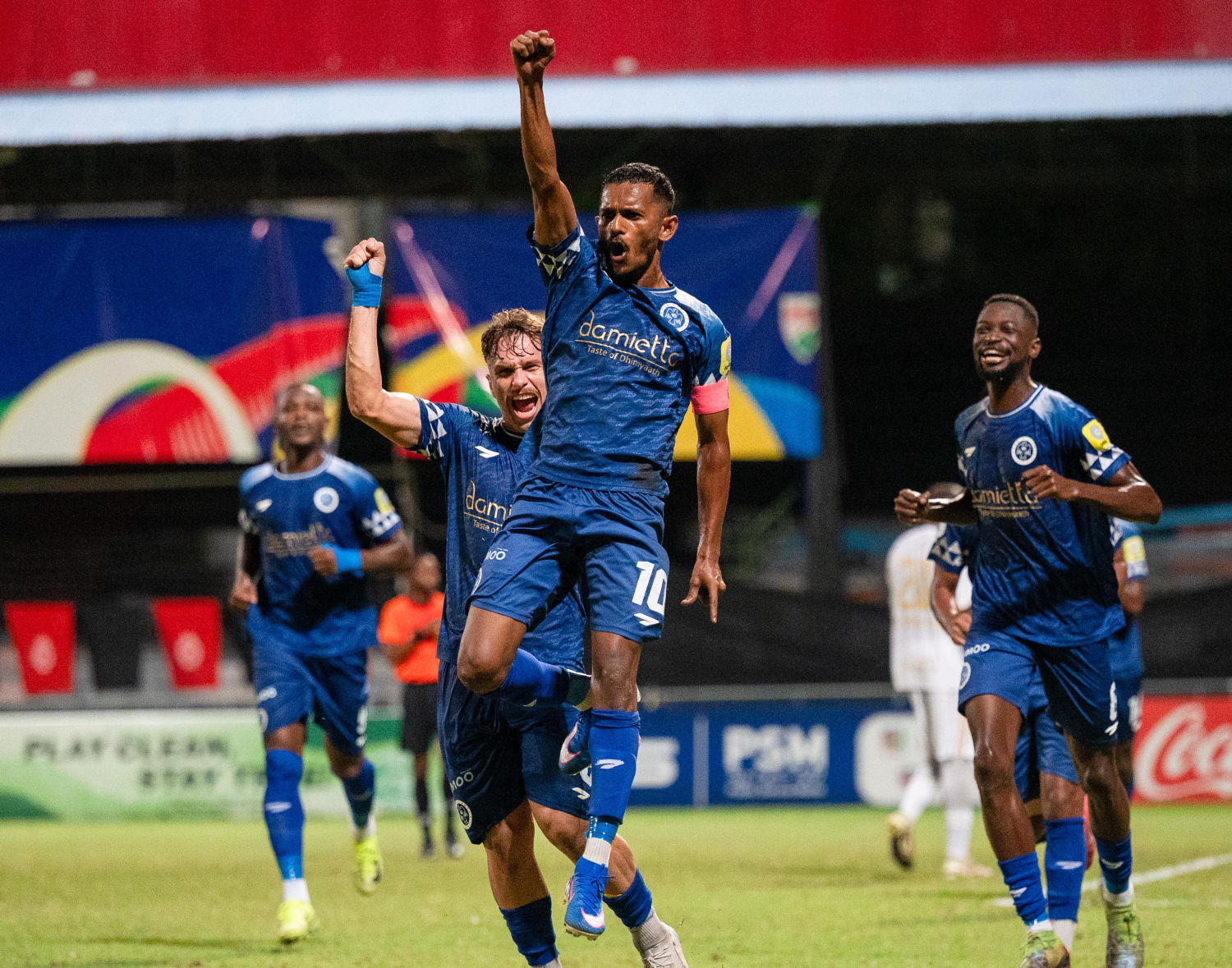 އެފްއޭކަޕް ފައިނަލު މެޗުގައި ޓީސީ ކޮޅަށް ފުރަތަމަ ލަނޑު ޖެހުމަށްފަހު އަލީ ފާސިރު (ސެންޓޭ) އުފާ ފާޅުކުރަނީ: ފުރަތަމަ ލަނޑު ކާމިޔާބުކުރީ ލިބުނު ޕެނަލްޓީއަކުން.-- ފޮޓޯ: ފަޔާޒު މޫސާ | މިހާރު